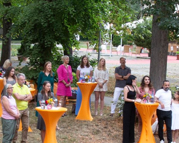 Gäste an Stehttischen im Park