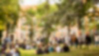 Merz Campus im Sommer mit vielen Gästen, sitzend und stehend, Backsteingebäude im Hintergrund